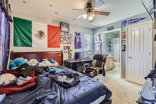 carpeted bedroom featuring ceiling fan, a textured ceiling, and ensuite bathroom