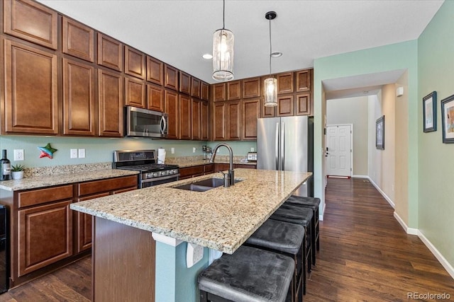 3115 Bryce Dr, Fort Collins, CO 80525 - kitchen featuring stainless steel appliances, dark wood-style floors, light stone counters, hanging light fixtures, and recessed lighting