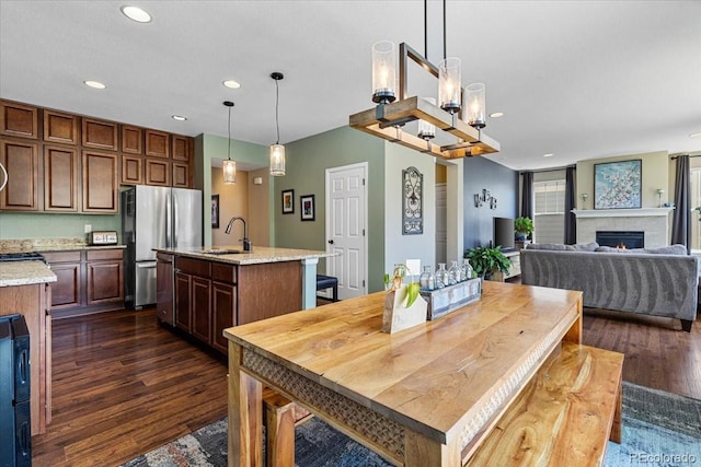 3115 Bryce Dr, Fort Collins, CO 80525 - dining room featuring dark wood-style floors, recessed lighting, a lit fireplace, and a chandelier
