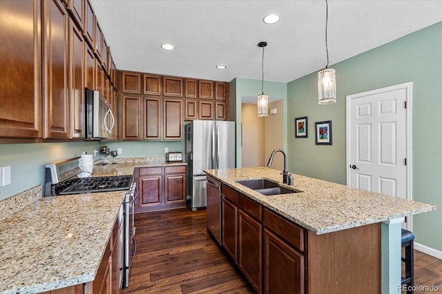 3115 Bryce Dr, Fort Collins, CO 80525 - kitchen with appliances with stainless steel finishes, dark wood-style flooring, a kitchen breakfast bar, a center island with sink, and recessed lighting
