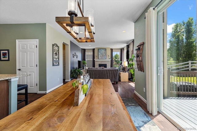 3115 Bryce Dr, Fort Collins, CO 80525 - dining space featuring dark wood finished floors, a chandelier, a fireplace, and recessed lighting