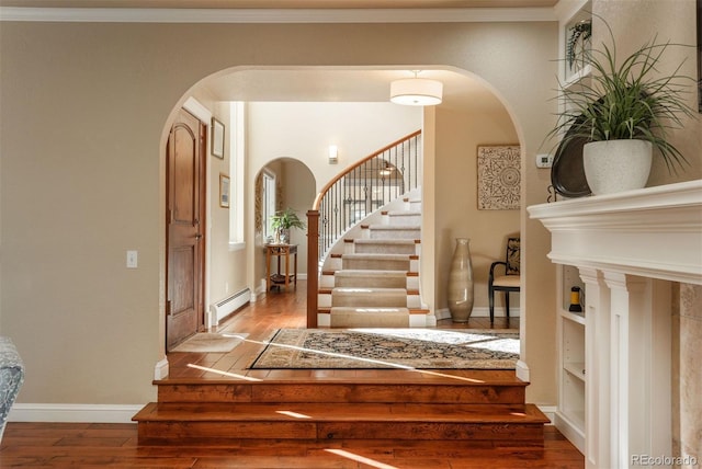 entryway featuring hardwood / wood-style flooring, a baseboard radiator, and ornamental molding