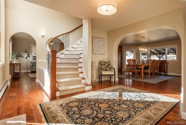 foyer entrance featuring a notable chandelier and dark hardwood / wood-style flooring