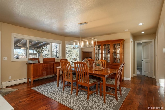 dining space with a baseboard radiator, dark hardwood / wood-style floors, a notable chandelier, and a textured ceiling