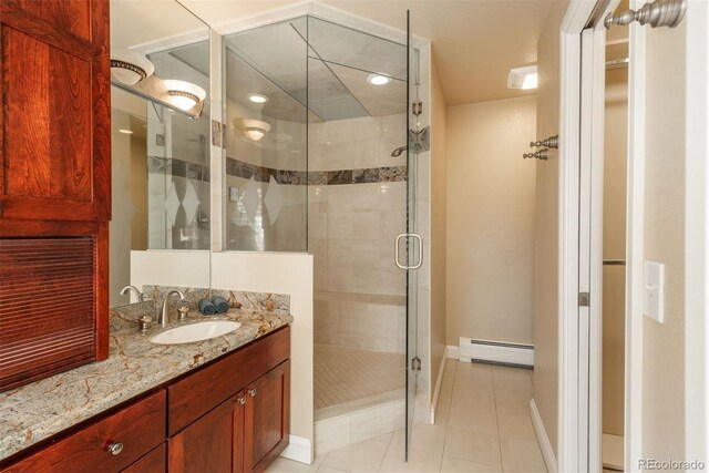 bathroom featuring vanity, a shower with shower door, tile patterned floors, and baseboard heating