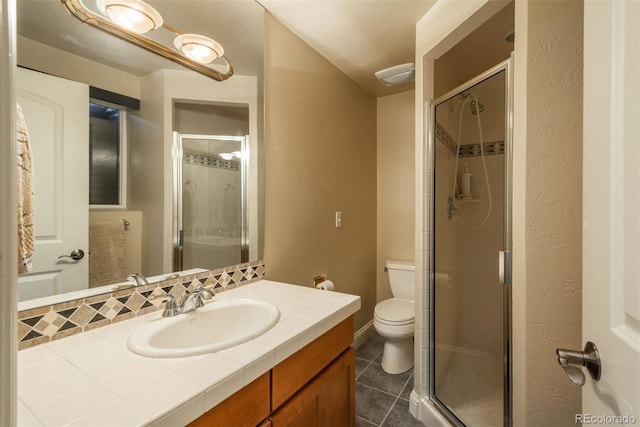 bathroom with vanity, toilet, a shower with shower door, and tile patterned flooring