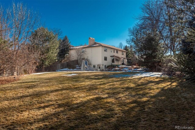 rear view of house featuring a yard