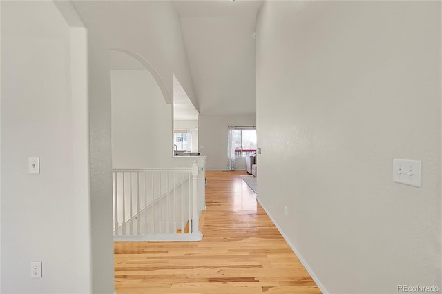 hallway featuring an upstairs landing and light wood finished floors