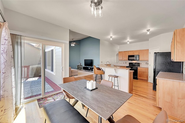 dining space featuring a ceiling fan and light wood finished floors