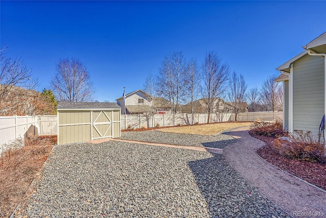 view of yard with an outbuilding, a storage shed, and a fenced backyard