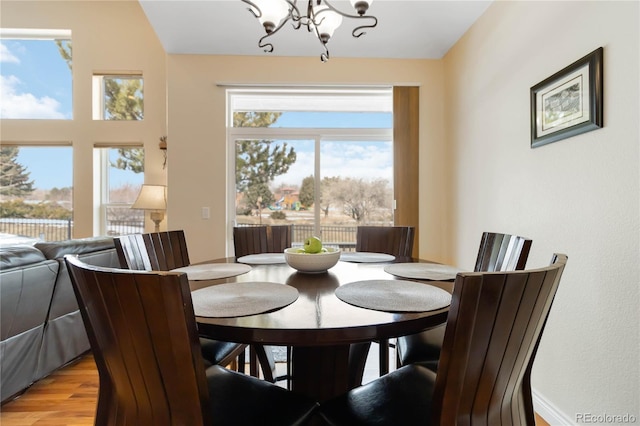 dining area featuring light wood-style flooring and a notable chandelier