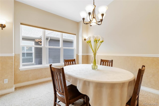 dining area with carpet floors, baseboards, and a chandelier