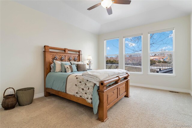 bedroom with baseboards, multiple windows, and light colored carpet