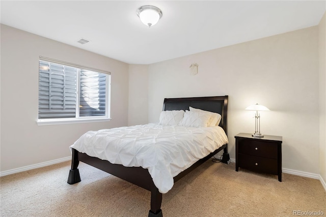 bedroom with light carpet, visible vents, and baseboards