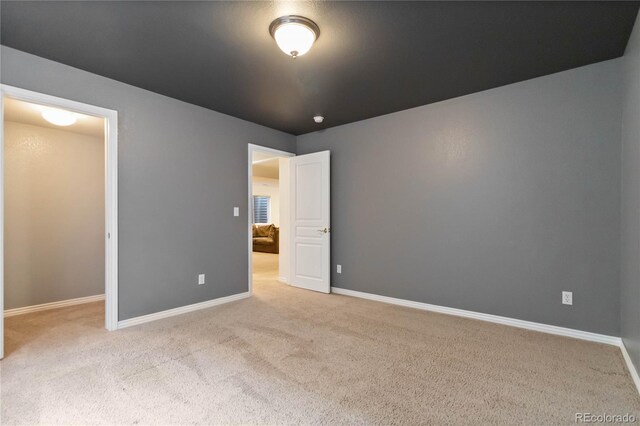 unfurnished bedroom with light carpet and baseboards