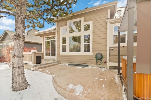 snow covered property featuring a patio area and fence