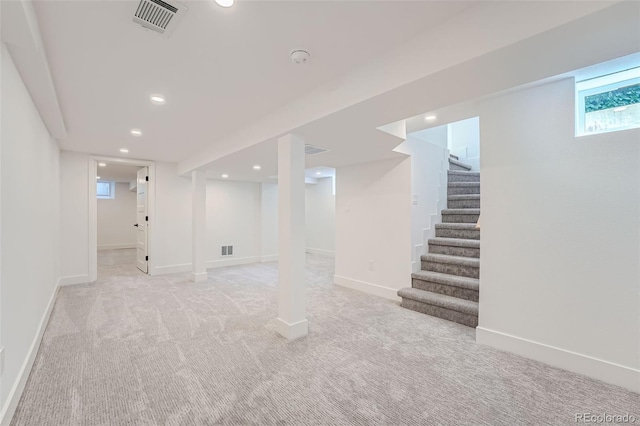 basement featuring stairway, baseboards, visible vents, and recessed lighting