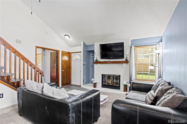 carpeted living area featuring stairs, a brick fireplace, and lofted ceiling
