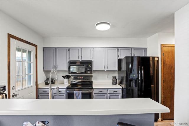 kitchen with light countertops, gray cabinets, and black appliances