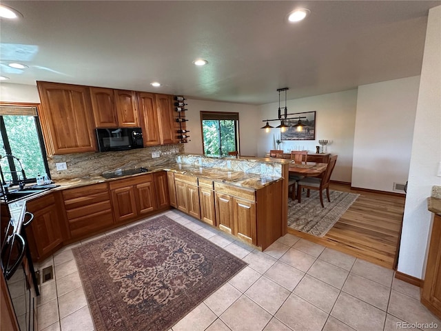 7454 Queen Cir, Arvada, CO 80005 - kitchen featuring black appliances, brown cabinetry, recessed lighting, light stone counters, and decorative backsplash