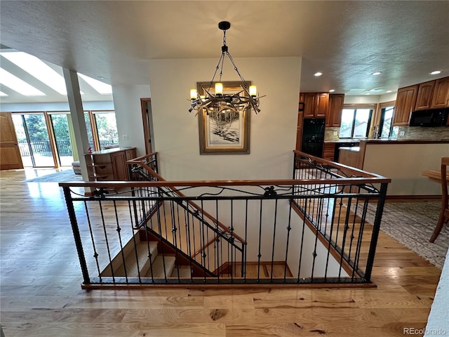 7454 Queen Cir, Arvada, CO 80005 - stairs featuring a chandelier, wood finished floors, and recessed lighting