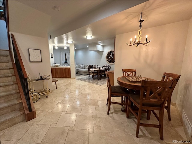 7454 Queen Cir, Arvada, CO 80005 - dining room featuring stairs, stone tile flooring, and a chandelier