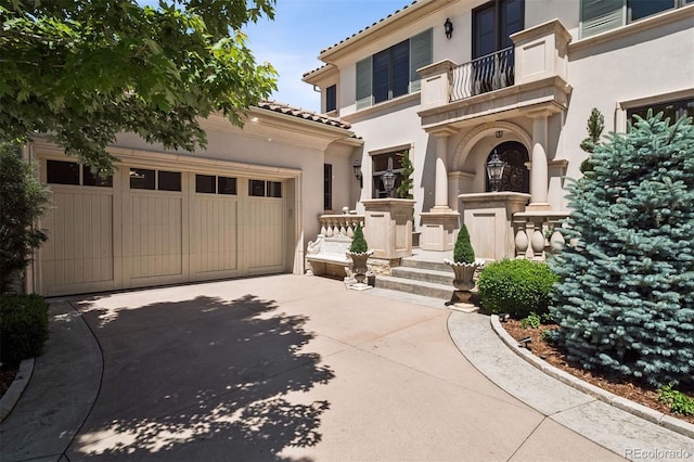 9171 E Harvard Ave, Denver, CO 80231 - mediterranean / spanish-style home featuring concrete driveway, stucco siding, a tile roof, and an attached garage