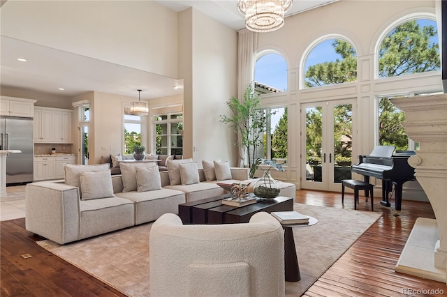 9171 E Harvard Ave, Denver, CO 80231 - living area featuring a towering ceiling, light wood-style flooring, recessed lighting, french doors, and a chandelier