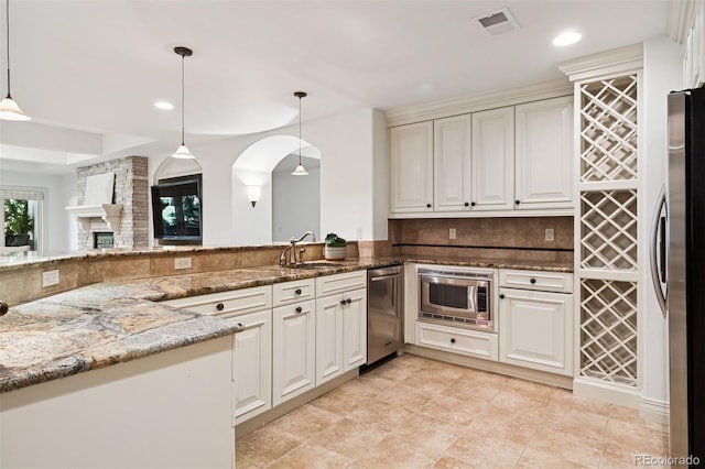 9171 E Harvard Ave, Denver, CO 80231 - kitchen featuring stainless steel appliances, stone counters, pendant lighting, tasteful backsplash, and recessed lighting