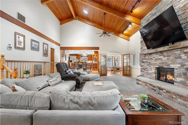 living area featuring visible vents, a stone fireplace, high vaulted ceiling, wooden ceiling, and a ceiling fan