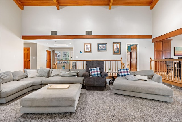 carpeted living room featuring visible vents, wooden ceiling, and a towering ceiling