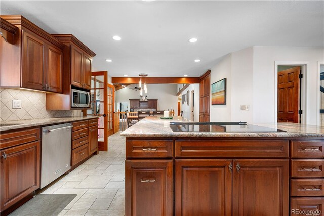 kitchen featuring recessed lighting, decorative backsplash, appliances with stainless steel finishes, and light stone countertops