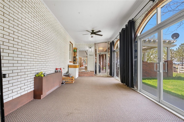 corridor with carpet floors and brick wall