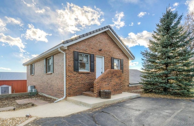 view of side of home with a patio and brick siding