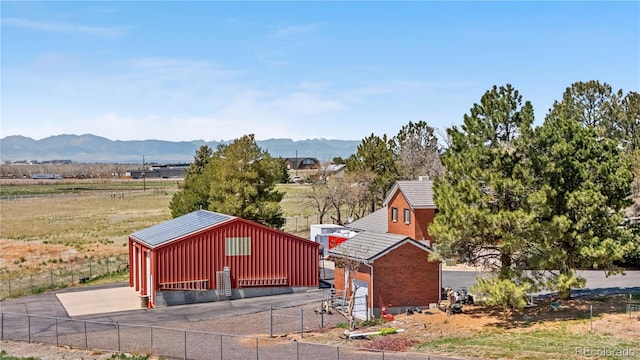 view of pole building with fence, a mountain view, and a garage