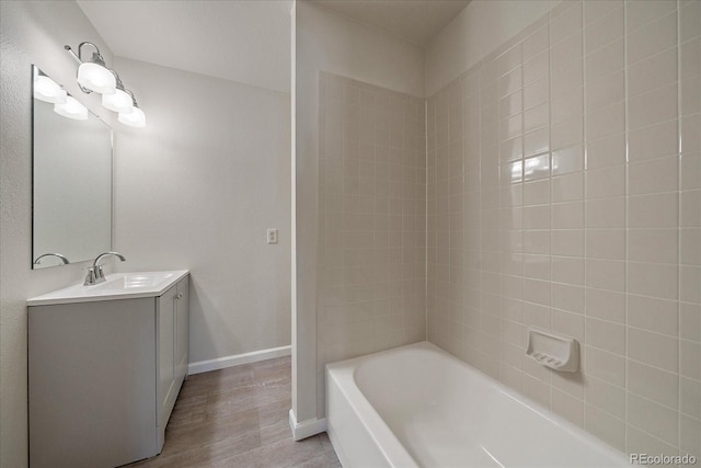 bathroom featuring wood finished floors, vanity, and  shower combination