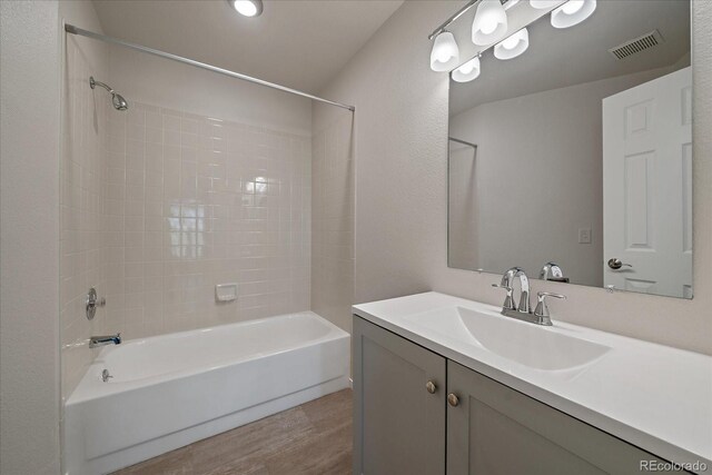 full bath with wood finished floors, washtub / shower combination, and vanity