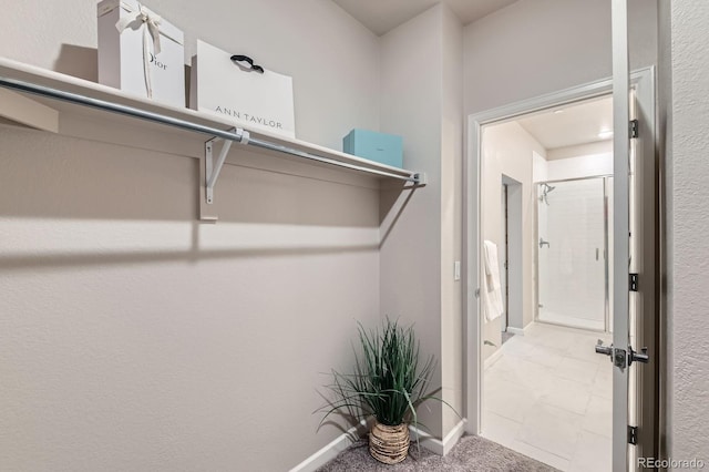 walk in closet with marble finish floor