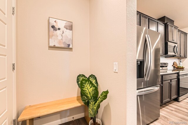 6153 N Ceylon St Unit 303, Denver, CO 80249 - kitchen with appliances with stainless steel finishes, light wood-style floors, and light stone counters
