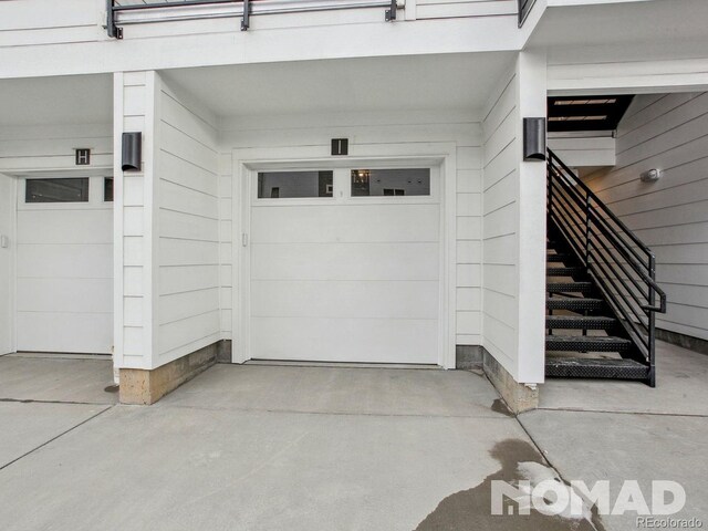 6153 N Ceylon St Unit 303, Denver, CO 80249 - view of exterior entry featuring a garage and concrete driveway