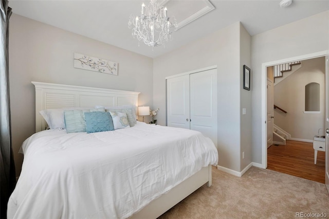 carpeted bedroom featuring a closet and a chandelier