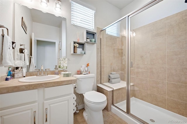 bathroom with vanity, tile patterned flooring, a shower with shower door, and toilet