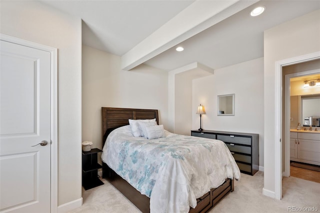 bedroom featuring light carpet, sink, and beamed ceiling