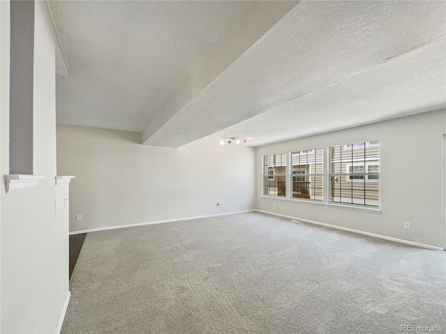 empty room with a textured ceiling and carpet floors