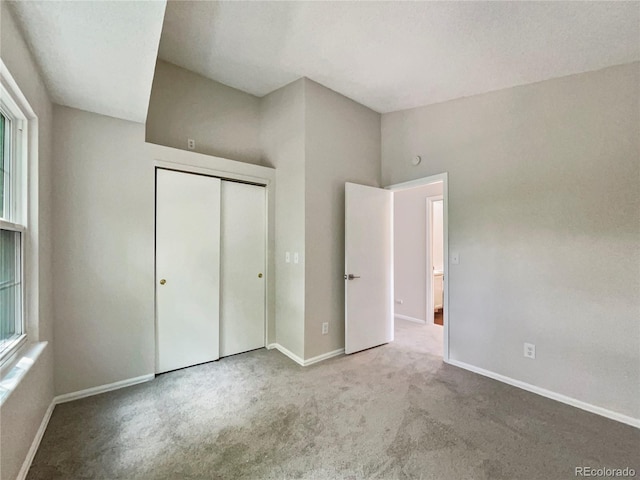 unfurnished bedroom with light carpet and a closet