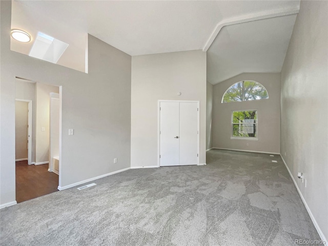 spare room with carpet floors and vaulted ceiling