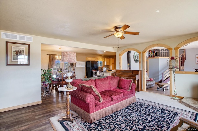 living room with wood-type flooring and ceiling fan with notable chandelier