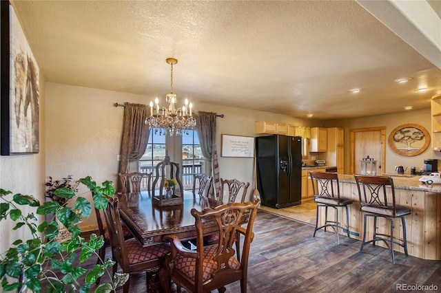 dining room featuring dark hardwood / wood-style flooring, a chandelier, and a textured ceiling