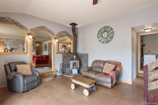 living room with a wood stove and ceiling fan