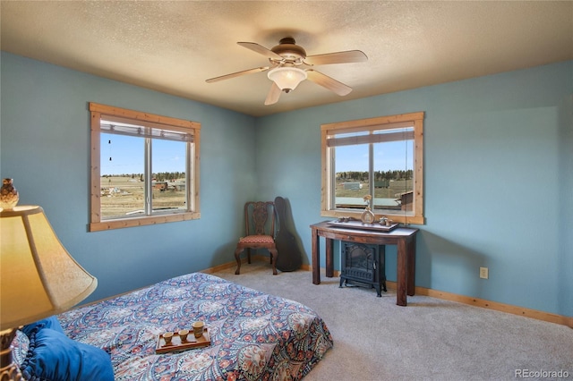 carpeted bedroom with ceiling fan and a textured ceiling